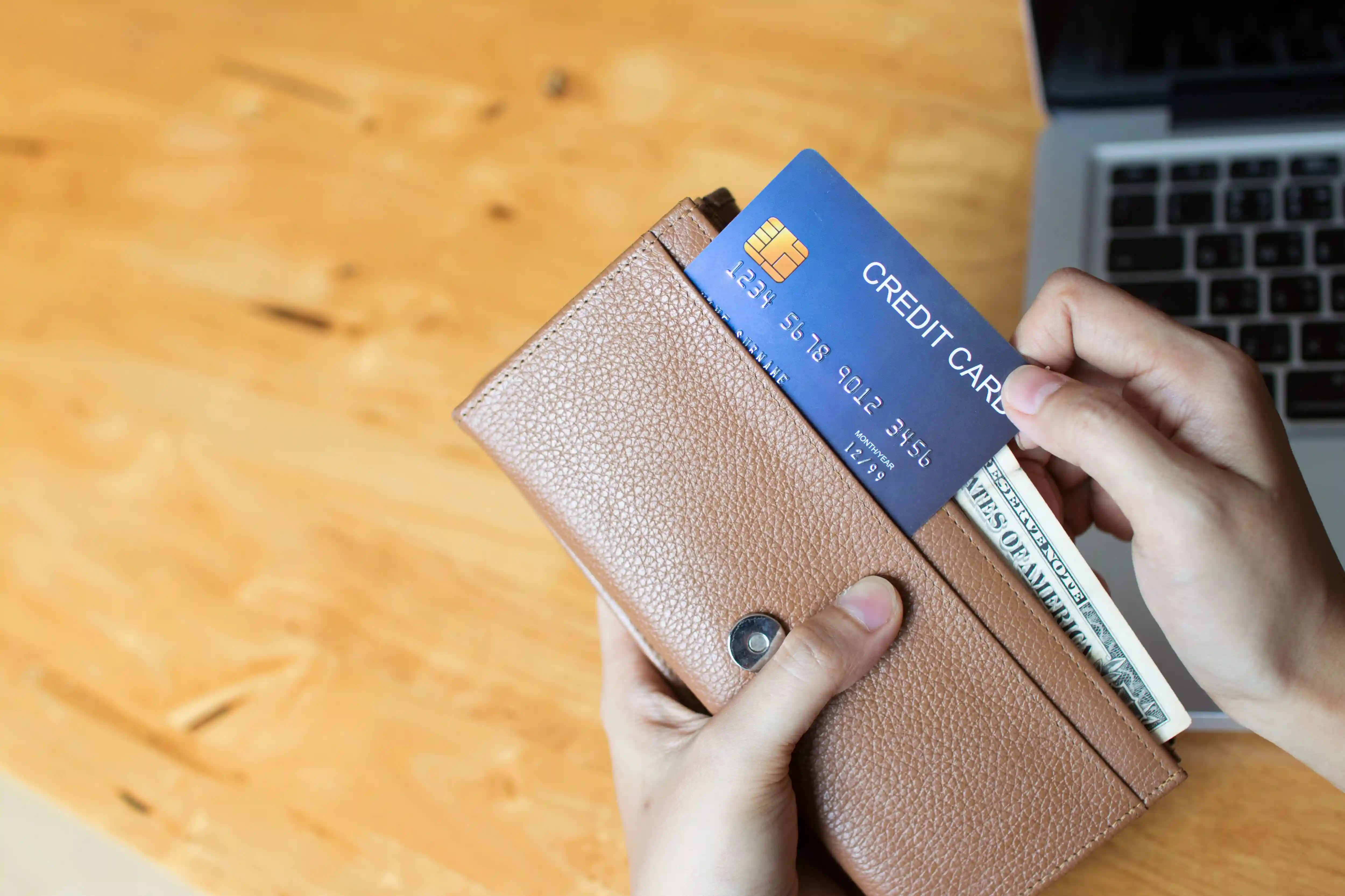 person pulling a credit card out of their wallet