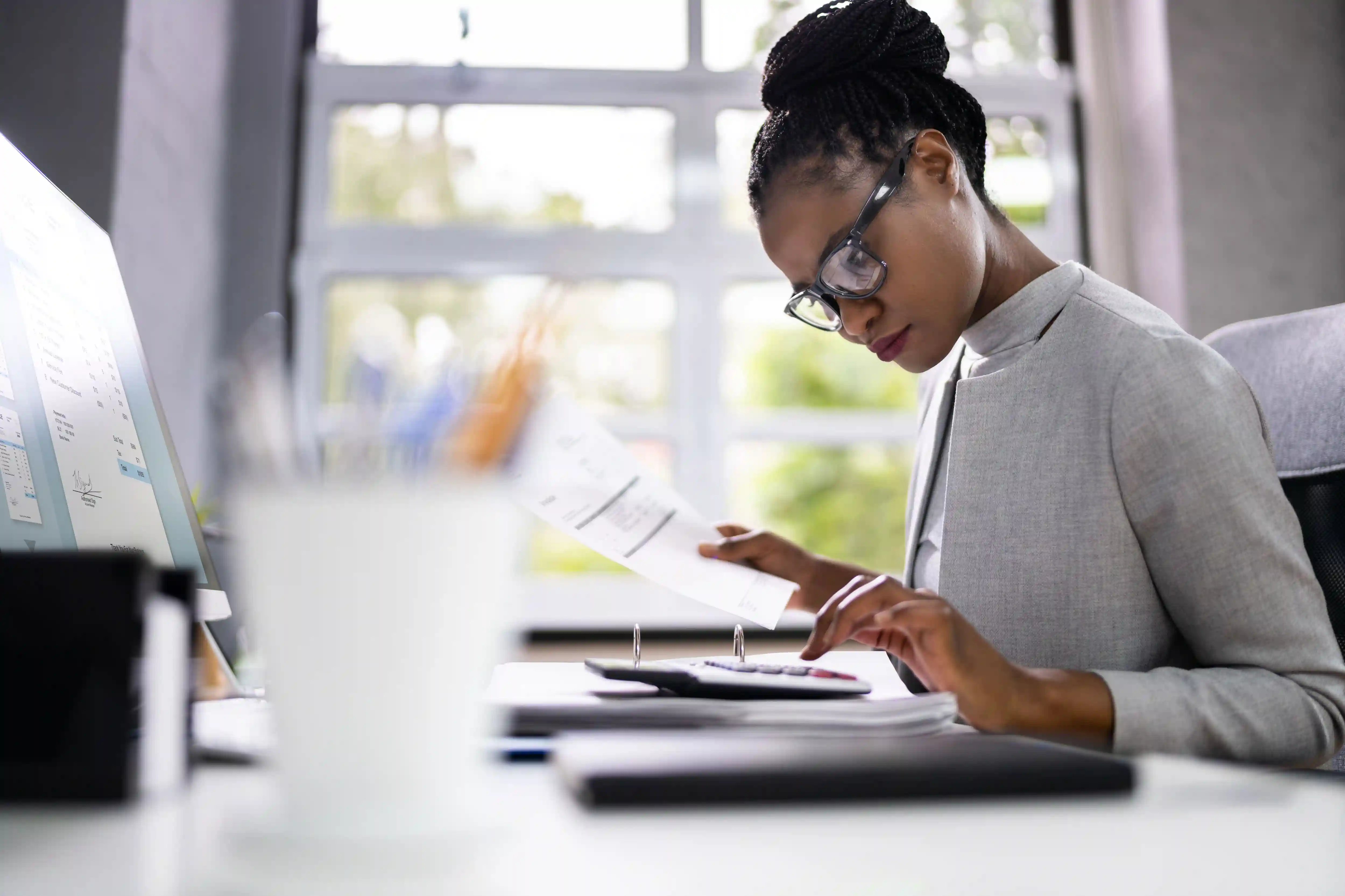 woman looking over forms with a calculator